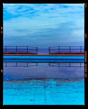 Load image into Gallery viewer, Photograph by Richard Heeps. The blue bay at Llandudno, cut across the middle with path and railings with a gap right in the middle.