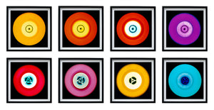 Photograph by Heidler and Heeps. Eight colourful vinyl records in black frames sit horizontally, 2 x 4.