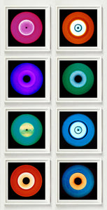 Photograph by Heidler and Heeps. Eight colourful vinyl records in white frames sit vertically, 2 x 4.
