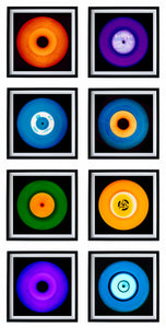 Photograph by Heidler and Heeps. Eight colourful vinyl records in black frames sit vertically, 2 x 4.