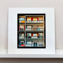 Load image into Gallery viewer, Mounted photograph by Richard Heeps. This is the balconies and balcony doors of 4 floors of flats located on the Rue Dezza. The colours of the walls alternate between red and grey but look different as the light catches them.