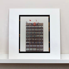 Load image into Gallery viewer, White mounted photograph by Richard Heeps. High rise offices with Martini logo on the top facade.