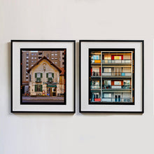 Load image into Gallery viewer, Two black framed photographs by Richard Heeps. On the left hand side is the photograph of a traditional Italian Tobacconist shop, here in a Swiss Cottage style building set against a vast urban apartment block. The right hand side photograph is of the balconies of a colourfully painted block of apartments.