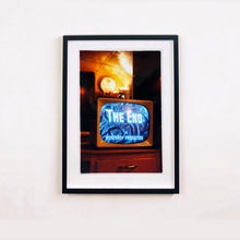 Load image into Gallery viewer, Black framed photograph by Richard Heeps. A retro small brown television sits on a wooden table displaying The End on a black and white film which shows as blue and white. In the background of the television is a warm light.