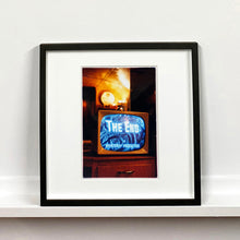 Load image into Gallery viewer, Black framed photograph by Richard Heeps. A retro small brown television sits on a wooden table displaying The End on a black and white film which shows as blue and white. In the background of the television is a warm light.