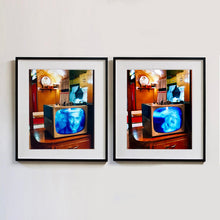 Load image into Gallery viewer, Two black framed photographs by Richard Heeps. Both photographs show a retro small brown television sitting on a wooden table displaying a black and white film, with the face of in turn Clark Gable and Marilyn Monroe, filling the screen, it shows as blue and white. In the background of the television is a warm wood-panelled light.