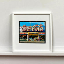 Load image into Gallery viewer, White framed photograph by Richard Heeps. Harry's Corner was taken on the wildwood boardwalk, featuring neon typography and the iconic Coca-Cola sign against a bright blue sky.