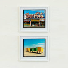 Load image into Gallery viewer, Two white framed photographs by Richard Heeps. The top photograph is of Harry's Corner and was taken on the wildwood boardwalk, featuring neon typography and the iconic Coca-Cola sign against a bright blue sky. The bottom photograph features four beach lockers, the two middle ones green and the two outer ones yellow, sitting on an empty beach with a blue sky.