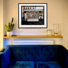 Load image into Gallery viewer, News Stand Milan, Italian street photography by Richard Heeps print framed in black on the wall.