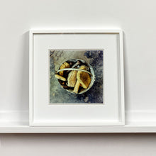 Load image into Gallery viewer, White framed photograph by Richard Heeps. A bucket with sponges, brushes and wooden handled tools sit in a bucket on a cracked cement floor.