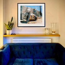 Load image into Gallery viewer, In situ black framed photograph by Richard Heeps. The broken off head of a giant fibreglass sculpture of a cowboy (a Muffler Man) lies on the ground.