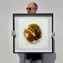Load image into Gallery viewer, Black framed photograph held by photographer Richard Heeps. A vintage pink soap dish sits on a white surface. Looking down onto the soap dish which contains two plugs, green soap, nail brush, cork and a sponge/wire wool combo.