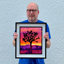 Load image into Gallery viewer, Richard holding Joshua Tree photography artwork framed in black