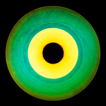 Load image into Gallery viewer, Photograph by Natasha Heidler and Richard Heeps.  A green vinyl record with purple grooves and swirls, in the centre a yellow label.   This sits on a black background.