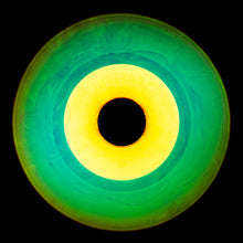 Load image into Gallery viewer, Photograph by Natasha Heidler and Richard Heeps.  A green vinyl record with purple grooves and swirls, in the centre a yellow label.   This sits on a black background.