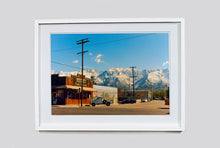 Load image into Gallery viewer, There is a cinematic style to this artwork, 'Lone Pine', taken in a former movie town in California where many Western films were made. Taken outside Richard's iconic interior photograph 'Bonanza Café', set in the Owens Valley against a mountainous  backdrop.