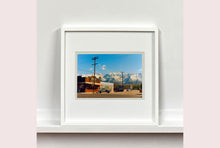 Load image into Gallery viewer, There is a cinematic style to this artwork, 'Lone Pine', taken in a former movie town in California where many Western films were made. Taken outside Richard's iconic interior photograph 'Bonanza Café', set in the Owens Valley against a mountainous  backdrop.