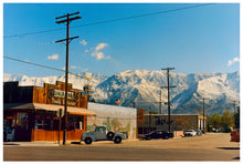 Load image into Gallery viewer, There is a cinematic style to this artwork, 'Lone Pine', taken in a former movie town in California where many Western films were made. Taken outside Richard's iconic interior photograph 'Bonanza Café', set in the Owens Valley against a mountainous  backdrop.