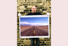 Load image into Gallery viewer, 'The Road to Death Valley', taken in the Majove Desert, California, features a clouded blue sky met my mountains on the horizon. This American landscape artwork is part of Richard Heeps' 'Dream in Colour' series. Taken in 2001, this artwork was first executed in Richard's darkroom in 2021.
