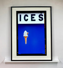 Load image into Gallery viewer, Black framed photograph by Richard Heeps.  At the top black letters spell out ICES and below is depicted a 99 icecream cone sitting left of centre against a blue coloured background.  