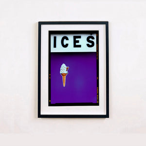 Black framed photograph by Richard Heeps.  At the top black letters spell out ICES and below is depicted a 99 icecream cone sitting left of centre against a purple coloured background.  