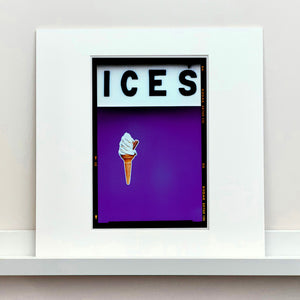 Mounted photograph by Richard Heeps.  At the top black letters spell out ICES and below is depicted a 99 icecream cone sitting left of centre against a purple coloured background.  