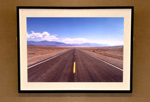Load image into Gallery viewer, 'The Road to Death Valley', taken in the Majove Desert, California, features a clouded blue sky met my mountains on the horizon. This American landscape artwork is part of Richard Heeps' 'Dream in Colour' series. Taken in 2001, this artwork was first executed in Richard's darkroom in 2021.