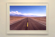 Load image into Gallery viewer, 'The Road to Death Valley', taken in the Majove Desert, California, features a clouded blue sky met my mountains on the horizon. This American landscape artwork is part of Richard Heeps' 'Dream in Colour' series. Taken in 2001, this artwork was first executed in Richard's darkroom in 2021.