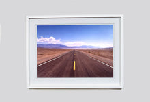 Load image into Gallery viewer, 'The Road to Death Valley', taken in the Majove Desert, California, features a clouded blue sky met my mountains on the horizon. This American landscape artwork is part of Richard Heeps' 'Dream in Colour' series. Taken in 2001, this artwork was first executed in Richard's darkroom in 2021.