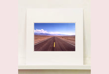 Load image into Gallery viewer, 'The Road to Death Valley', taken in the Majove Desert, California, features a clouded blue sky met my mountains on the horizon. This American landscape artwork is part of Richard Heeps' 'Dream in Colour' series. Taken in 2001, this artwork was first executed in Richard's darkroom in 2021.