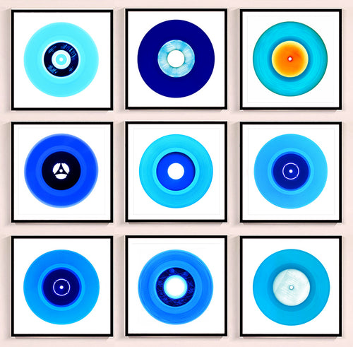 Photograph by Heidler and Heeps. A set of 9 different blue vinyls in a black frame. They are displayed in a square 3 x 3 format.