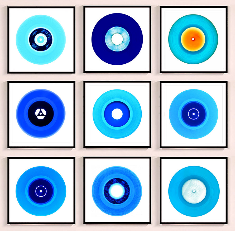 Photograph by Heidler and Heeps. A set of 9 different blue vinyls in a black frame. They are displayed in a square 3 x 3 format.