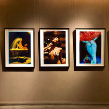 Load image into Gallery viewer, Three framed art prints featuring colorful artistic burlesque photographs by Richard Heeps, displayed side-by-side on a dark brown gallery wall under spotlights.