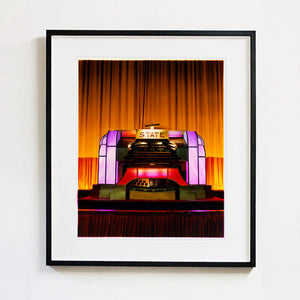 Framed photograph of a theater stage with 'State' on the proscenium arch.