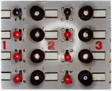 Load image into Gallery viewer, Photograph by Richard Heeps. A grey panel with four vertical lines of knobs alternating from left to right with three red knobs and one black knob, next to four black bigger knobs, this repeats. Then along the horizontal middle are numbers in red 1, 2 and 3.