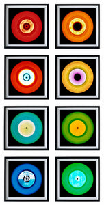 Photograph by Heidler and Heeps. Eight colourful vinyl records in black frames sit vertically, 2 x 4.