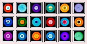 Photograph by Heidler and Heeps. 18 colourful vinyls in black frames, sitting horizontally in a 6 x 3 format.
