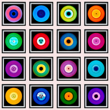 Load image into Gallery viewer, Photograph by Heidler and Heeps. A set of 16 colourful vinyls in black frames, set out in a 4 x 4 format.