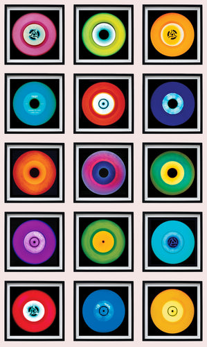 Photograph by Heidler and Heeps. A set of 15 colourful vinyls in black frames. They are sitting vertically in a 3 x 5 formation.