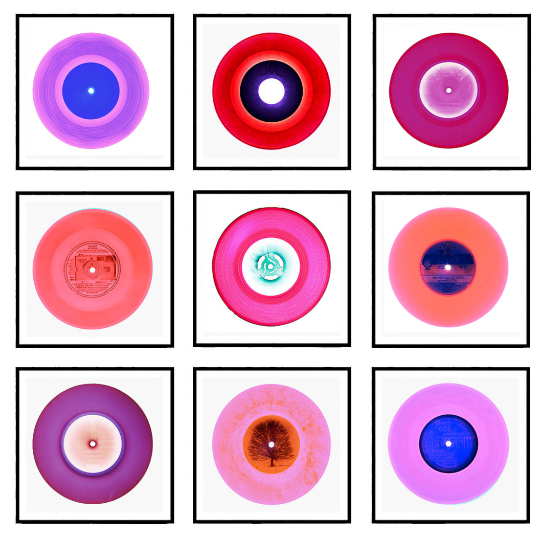 Photograph by Heidler and Heeps. A selection of 9 pink vinyl disks, set in white mounts, with black frames. Mounted in a 3x3 square.