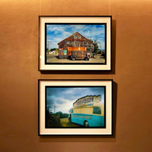 Load image into Gallery viewer, Two black framed photographic prints hanging vertically on a warm brown wall. Model T and Garage and Fish and Chips Van