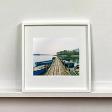 Load image into Gallery viewer, Ormesby Little Broad, a docking jetty with small boats stretches out to the Norfolk Broad photograph by Richard Heeps mounted square framed in white.