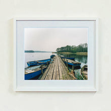 Load image into Gallery viewer, Ormesby Little Broad, a docking jetty with small boats stretches out to the Norfolk Broad photograph by Richard Heeps small framed in white.