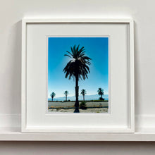 Load image into Gallery viewer, Palm Tree silhouette against blue California sky Salton Sea small white photograph by Richard Heeps