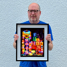 Load image into Gallery viewer, Richard Heeps holding Lights of Mong Kok Hong Kong street photography framed in black.