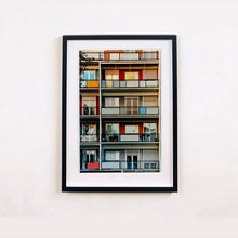 Load image into Gallery viewer, Black framed photograph by Richard Heeps. A colourful set of walls and balconies over five floors.