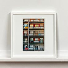 Load image into Gallery viewer, White framed photograph by Richard Heeps. A colourful set of walls and balconies over five floors.