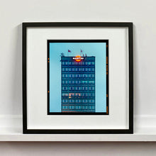 Load image into Gallery viewer, Black framed photograph by Richard Heeps. High rise offices in a blue light with Martini logo on the top facade. 