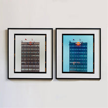 Load image into Gallery viewer, Two black framed photographs by Richard Heeps. Both photos are of a high rise office building with Martini logo on the top facade.  Photographed at different times of day the left hand photograph is in a grey light and the right hand side photo is in a blue light.