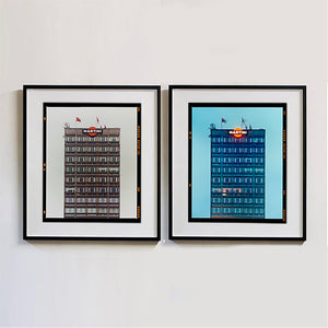 Two black framed photographs by Richard Heeps. Both photos are of a high rise office building with Martini logo on the top facade.  Photographed at different times of day the left hand photograph is in a grey light and the right hand side photo is in a blue light.